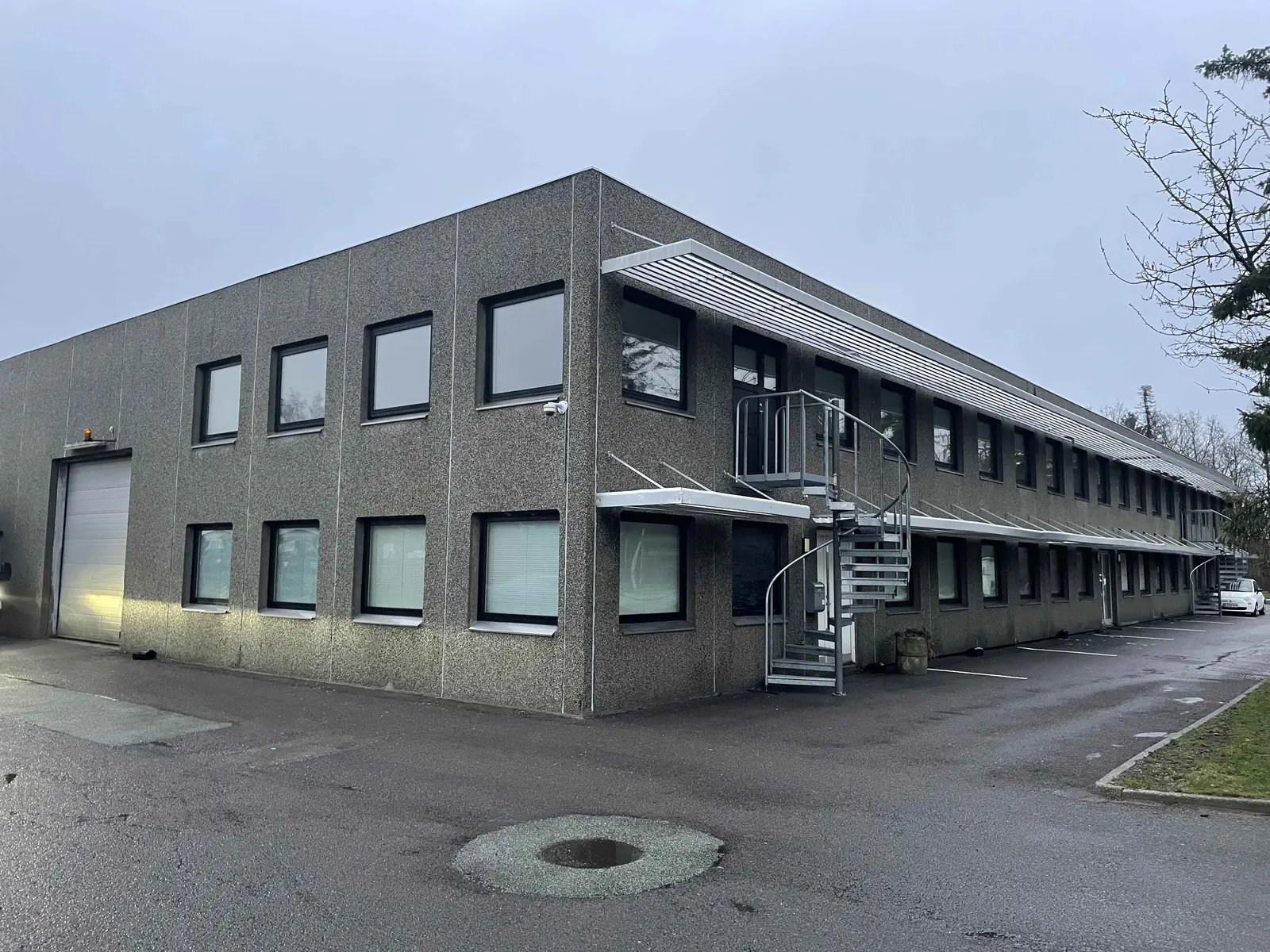 Kontorbygning med adgangstrappe og belagte udearealer